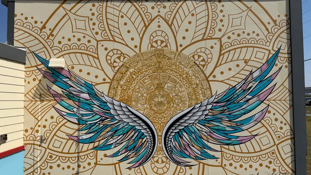 Wings mural and Aztec calendar inside Mercado El Valle